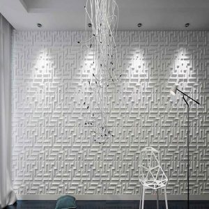 La imagen muestra una habitación con un muro blanco en Bogotá. Esta habitación está iluminada por una lámpara colgante moderna con diseño 3D. El ambiente se ve minimalista y elegante, donde la lámpara agrega un toque contemporáneo al espacio.