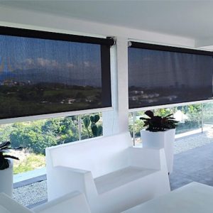 Imagen de una sala con muebles y decoración blanca, con unos ventanales con paneles negros que contrastan el ambiente