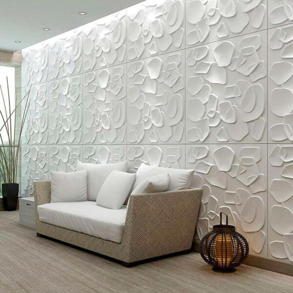 Esta es una imagen de una sala de estar decorada con un panel decorativo en 3D hecho de fibra vegetal, con referencia DL093. Los paneles están pintados en blanco, lo que le otorga un aspecto limpio y fresco a la sala. Además cuenta con un sofá cómodo, lo que hace que el espacio sea acogedor para los visitantes.