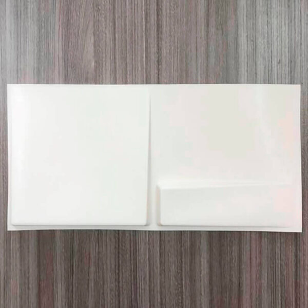 La imagen muestra un panel decorativo 3D, de color blanco, colocado sobre una superficie de madera en Bogotá. El panel tiene un diseño tridimensional que le da un aspecto atractivo y moderno. La combinación del blanco puro del panel con el tono natural de la madera crea un contraste interesante y elegante. Parece ser una pieza decorativa para una casa o un establecimiento comercial, añadiendo textura y profundidad al espacio.